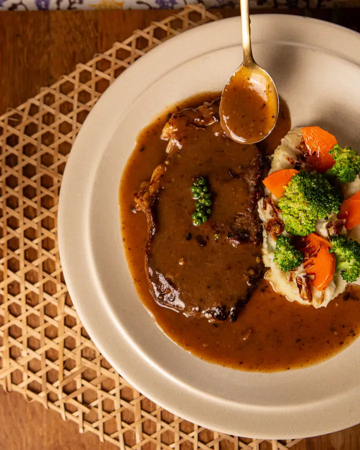 Sirloin steak bersos lada hitam dengan kentang lecek, brokoli dan lobak merah