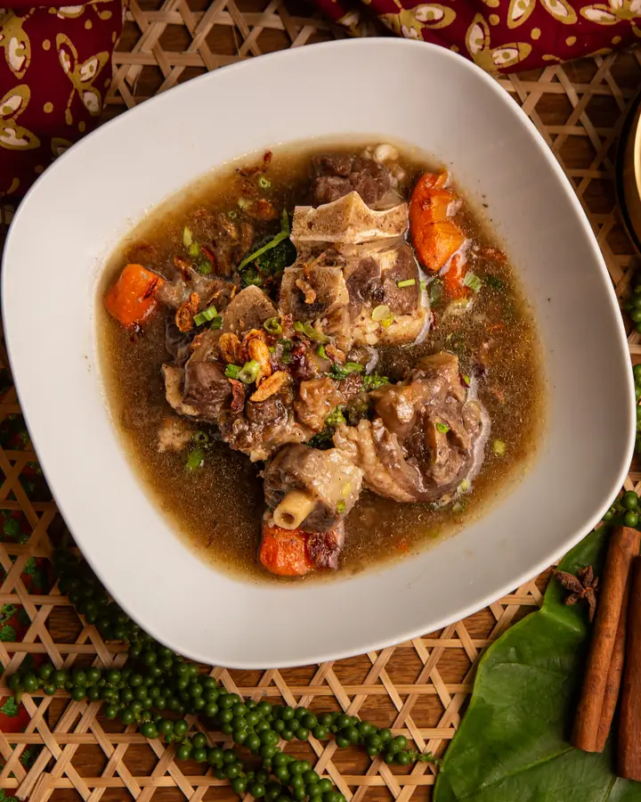 Sup tulang dengan lobak merah dan daun sup, dihidang bersama semangkuk nasi putih